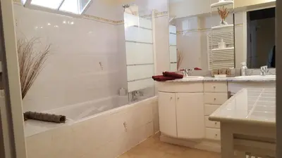 a white bathroom with a tub and a sink at Les Roues de L'Isle - CHARMING APARTMENT in LʼIsle-sur-la-Sorgue