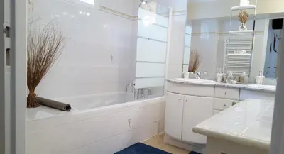 a white bathroom with a tub and a sink at Les Roues de L'Isle - CHARMING APARTMENT in LʼIsle-sur-la-Sorgue