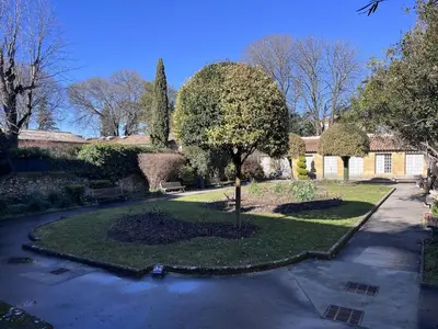 a garden with a tree in the middle of a driveway at Aix-en-Provence, Studio rénové au coeur de ville Calme absolu in Aix-en-Provence