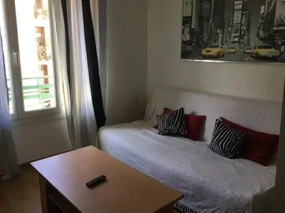 a room with a bed and a table and a window at appartement de charme au coeur d'aix en provence in Aix-en-Provence