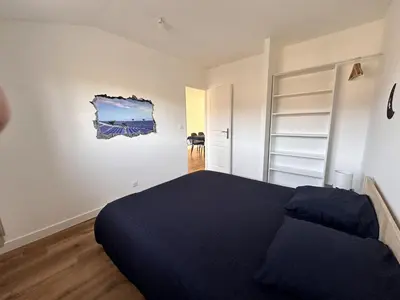 a bedroom with a bed and a painting on the wall at L'abeille sous les étoiles in Saint-Michel-lʼObservatoire