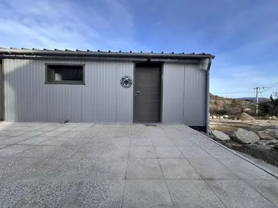 a white garage with a door and a driveway at L'abeille sous les étoiles in Saint-Michel-lʼObservatoire