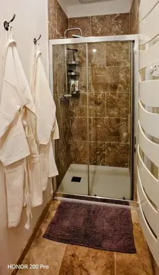 a bathroom with a shower with a glass door at Charmant studio aux portes des Alpilles in Eyguières