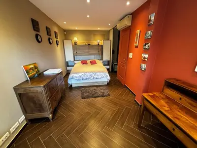a bedroom with a bed and a wooden floor at T2 avec Terrasse à Ventabren proche Aix in Ventabren