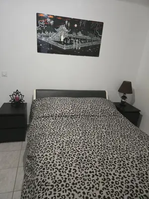 a bed with a black and white comforter in a bedroom at Le cocon de mag in Miramas