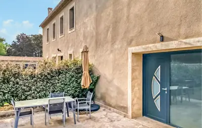 a patio with a table and chairs and an umbrella at Amazing Home In Noves in Noves