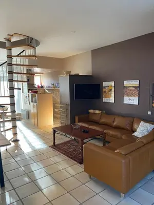 a living room with a brown couch and a coffee table at Karen house with courtyard at the foot of the Luberon in Maubec