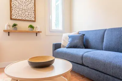 a living room with a blue couch and a table at Le Petit Saint Esprit, centre, calme, lumineux in Aix-en-Provence