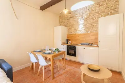 a kitchen with a table and chairs in a room at Le Petit Saint Esprit, centre, calme, lumineux in Aix-en-Provence