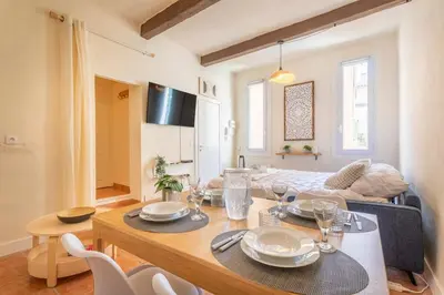 a living room with a dining room table and a couch at Le Petit Saint Esprit, centre, calme, lumineux in Aix-en-Provence