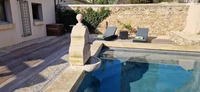 a swimming pool with two laptops sitting next to a house at superbe escapade au cœur de la ville clim parking et piscine in Aix-en-Provence