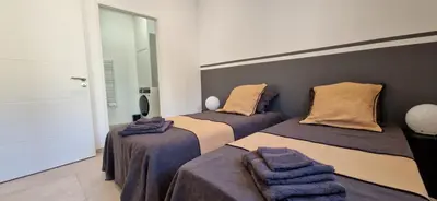 a bedroom with two beds with blankets on them at superbe escapade au cœur de la ville clim parking et piscine in Aix-en-Provence