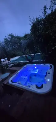a hot tub sitting on top of a wooden deck at Villa de charme avec piscine et jacuzzi en Provence in Châteauneuf-de-Gadagne