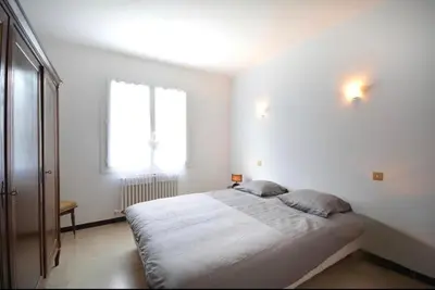 a white bedroom with a large bed with a window at Les Volets Bleus Provençal house with pool in LʼIsle-sur-la-Sorgue