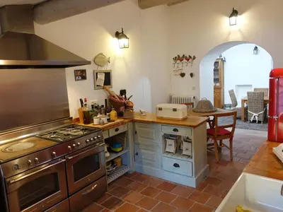 a kitchen with an oven and a table with a dining room at La maison de la lumière in Cucuron