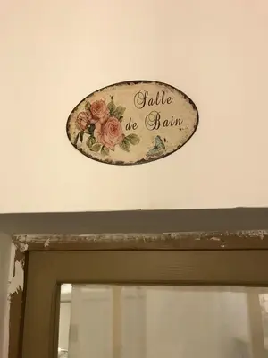 a sign above a door with flowers on it at La maison de la lumière in Cucuron