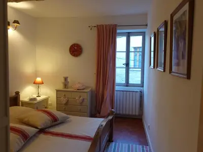 a bedroom with a bed and a window at La maison de la lumière in Cucuron
