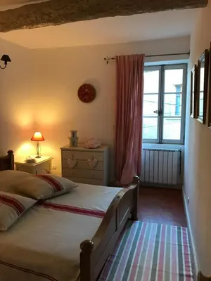 a bedroom with a bed and a window at La maison de la lumière in Cucuron