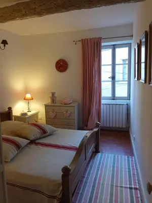 a bedroom with two beds and a window at La maison de la lumière in Cucuron