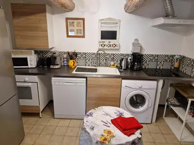 a kitchen with a sink and a washing machine at Gîte Moulin de l'Anet in Goult