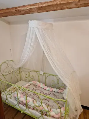 a green bed with a canopy in a room at Gîte Moulin de l'Anet in Goult