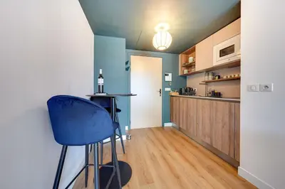 a kitchen with a blue bar stool in a room at Downtown suite, parking, loggia, elevator, quiet in Aix-en-Provence