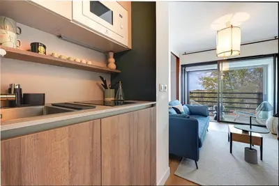 a kitchen and living room with a couch and a table at Downtown suite, parking, loggia, elevator, quiet in Aix-en-Provence