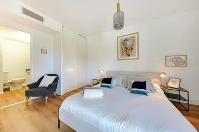 a bedroom with a large white bed and a chair at Downtown suite, parking, loggia, elevator, quiet in Aix-en-Provence
