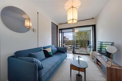 a living room with a blue couch and a large window at Downtown suite, parking, loggia, elevator, quiet in Aix-en-Provence