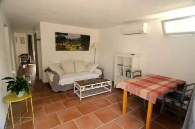 a living room with a couch and a table at Le Petit Pont - Au bord de la rivière in LʼIsle-sur-la-Sorgue
