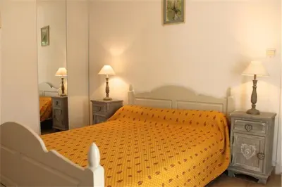a bedroom with an orange bed with two night stands at Le Castor et La Loutre - Gites en bord de Sorgue in LʼIsle-sur-la-Sorgue