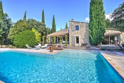 a large swimming pool in front of a house at La Garrigue de Gordes in Gordes