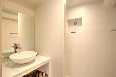 a white bathroom with a sink and a mirror at La Garrigue de Gordes in Gordes