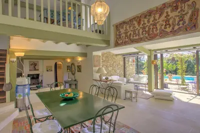a kitchen and living room with a table and chairs at La Garrigue de Gordes in Gordes