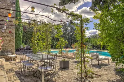 a patio with a table and chairs and a pool at La Garrigue de Gordes in Gordes