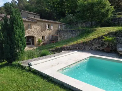a swimming pool in a yard next to a building at le Mas caché in Ménerbes