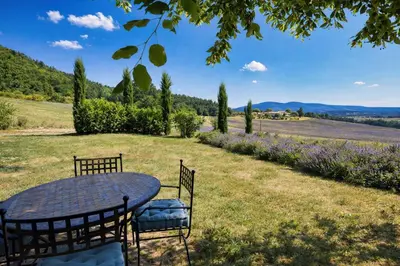 a table and chairs in a field with flowers at La Grange Blanche in Sault-de-Vaucluse