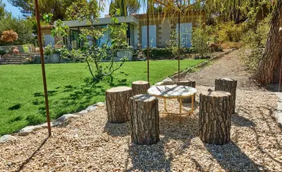 a garden with a table and some logs at Villa Cezanne Panorama, City Center on Foot in Aix-en-Provence