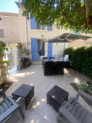 a patio with two benches and an umbrella at La Cigale Bleue in Villes-sur-Auzon