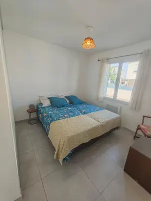a bedroom with a bed with blue pillows and a window at Casa LoVaPi Cozy recent 2-bedroom house, garden, private parking in Salon-de-Provence