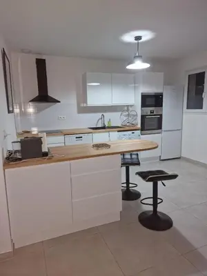 a kitchen with white cabinets and a wooden counter top at Casa LoVaPi Cozy recent 2-bedroom house, garden, private parking in Salon-de-Provence