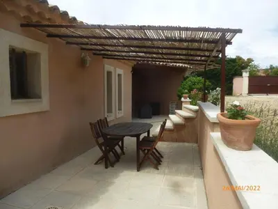 a patio with a table and chairs under a pergola at Très charmant Mazet au coeur du Luberon in Roussillon