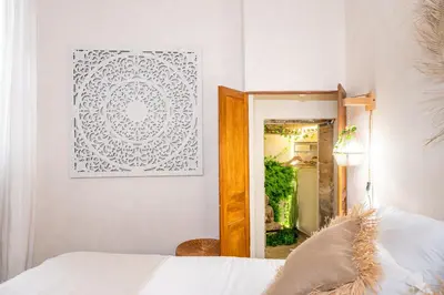 a bedroom with a mirror and a picture on the wall at La Cour Secrète - 2 Suites avec Balnéo privée in Carpentras