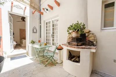a patio with a fireplace and a table and a chair at La Cour Secrète - 2 Suites avec Balnéo privée in Carpentras