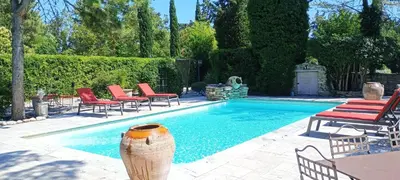 a swimming pool with chairs and a table at luxury farm jacuzzi heated pool in Isle sur la sorgue in Lagnes