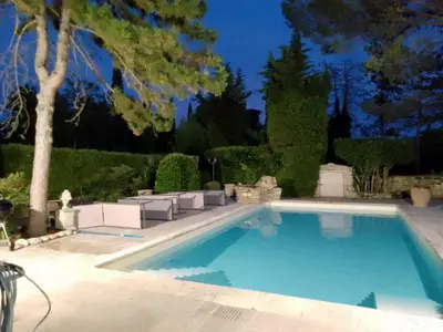 a swimming pool in a yard with chairs and trees at luxury farm jacuzzi heated pool in Isle sur la sorgue in Lagnes