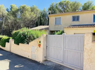 a white fence in front of a house at Une maison provençale dans la pinède - A Provençal house in a pine forest in Lambesc