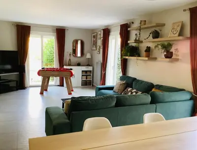 a living room with a green couch and a table at Une maison provençale dans la pinède - A Provençal house in a pine forest in Lambesc
