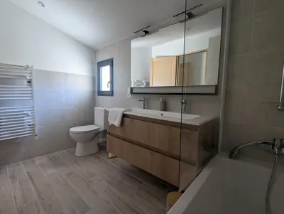 a bathroom with a tub and a toilet and a sink at La Ferme Au bord de l etang de la Bonde in Sannes