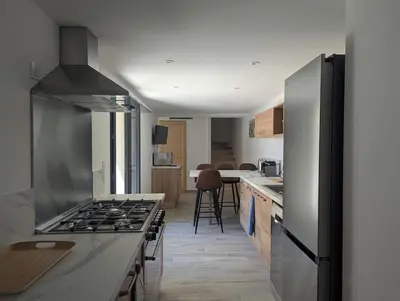 a kitchen with a stove top oven in a room at La Ferme Au bord de l etang de la Bonde in Sannes